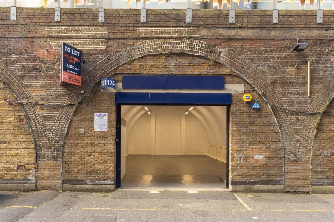 The front of an arch with an open electric roller shutter entrance big enough for vehicle access, and separate pedestrian door.