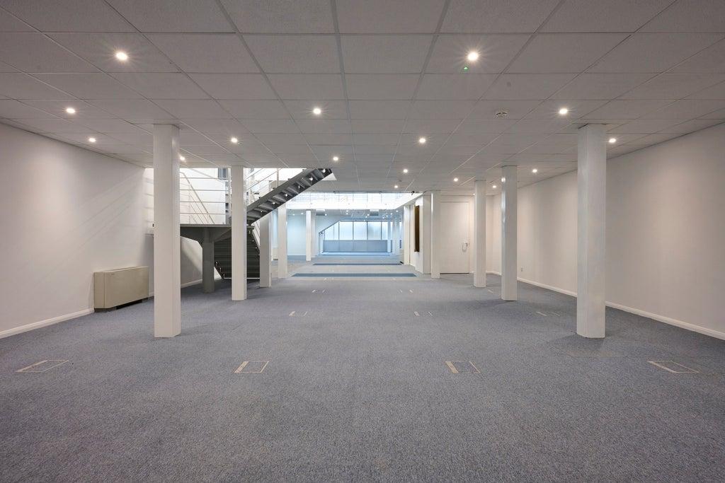 The ground floor of an empty arch, suitable to use as an office unit, with carpet and a WC.