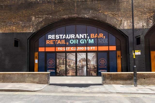 The front of an arch, with a fully glazed frontage and door allowing you to see into the arch interior.