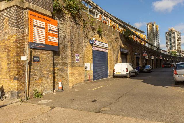 An estate, with multiple arches next to each other. The arches have closed electric roller shutter entrances.