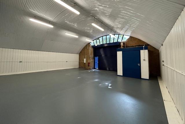 An empty arch with white lining and a WC cubicle to the front.